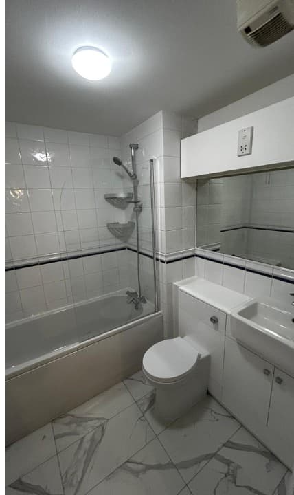 A tired bathroom stripped back, waterproofed and finished with marble-effect tiling — a real Haus project.